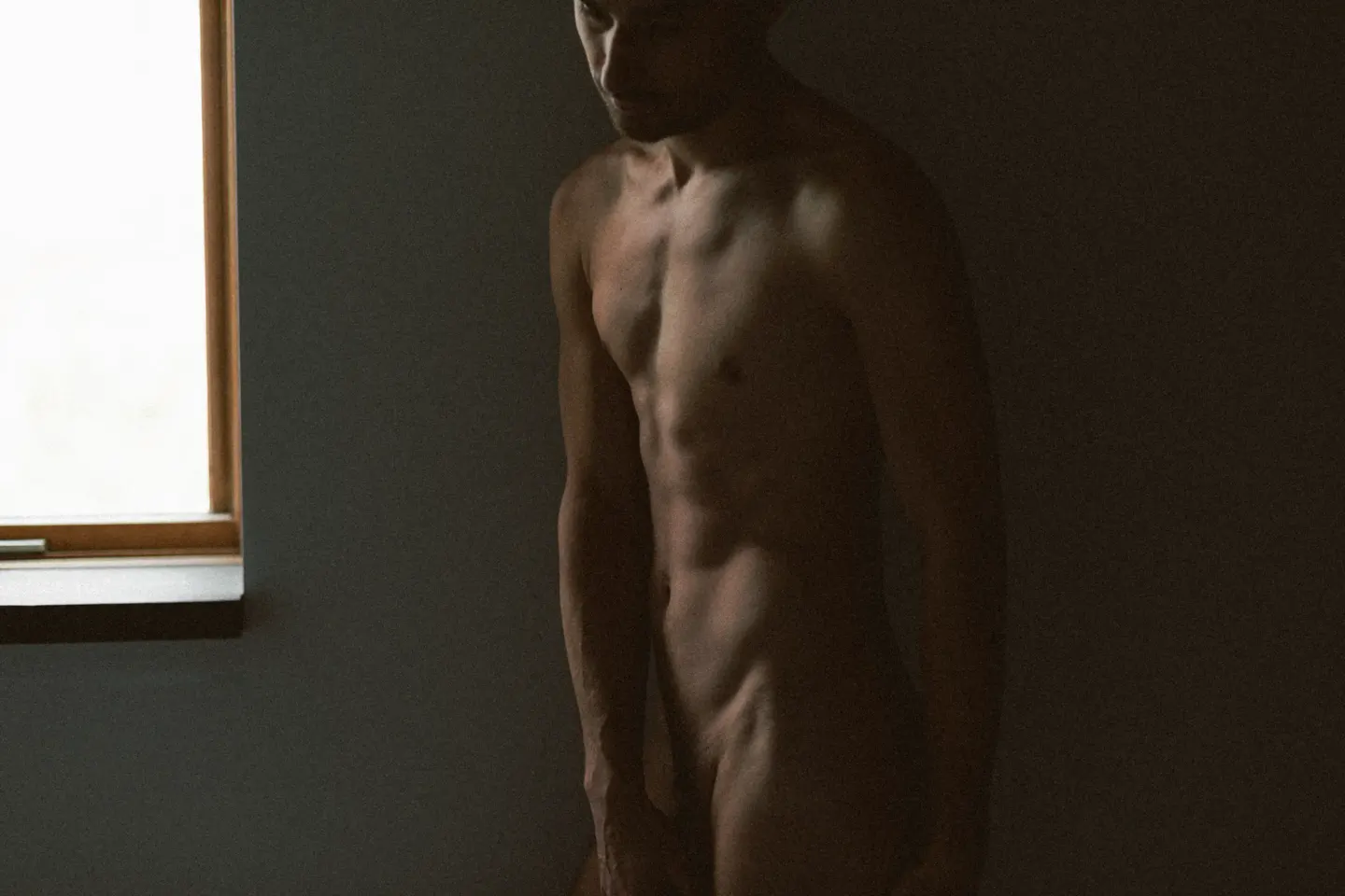 Nu masculin silhouette lumière naturelle — séance boudoir homme Montréal